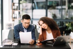 Two professionals reviewing estate documents together at a desk with a gavel